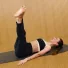 Soft Total Body session with Carlotta Gagna lying on a mat with both legs extended upward and arms by her sides in Pilates Linfodrenante® Express