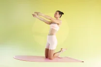 Sessione con Carlotta Gagna in ginocchio su un tappetino con entrambe le braccia distese in avanti e un piede sollevato dietro di sé in Pilates Linfodrenante®