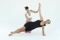 Esercizio di Pilates in gravidanza: Carlotta Gagna guida una donna nel plank laterale con un braccio teso verso l'alto, per rinforzare core e obliqui, nel programma Pilates Linfodrenante® Gravidanza